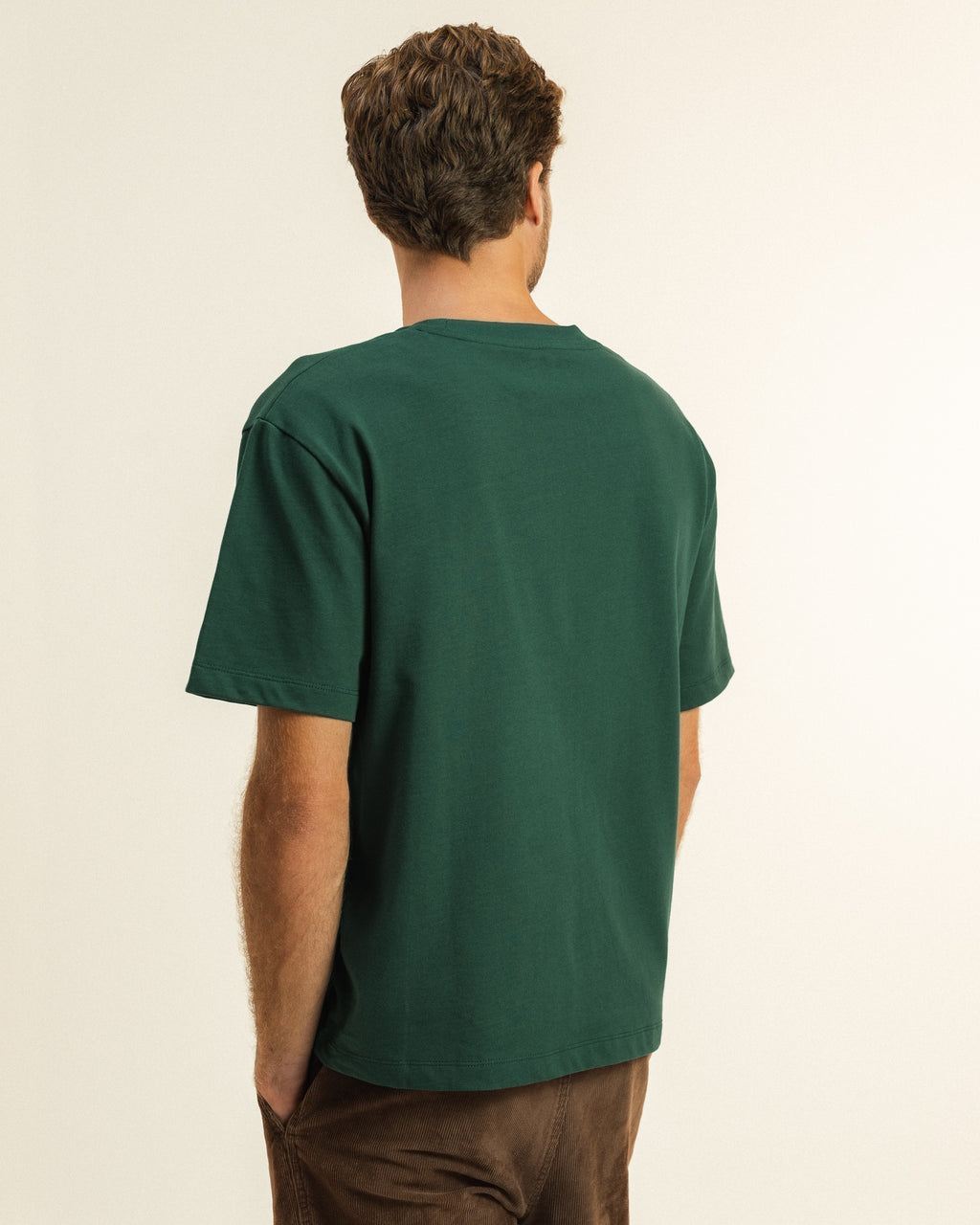 Back view of a man modeling the Feel the ocean's heartbeat T-shirt by Coral Raw.