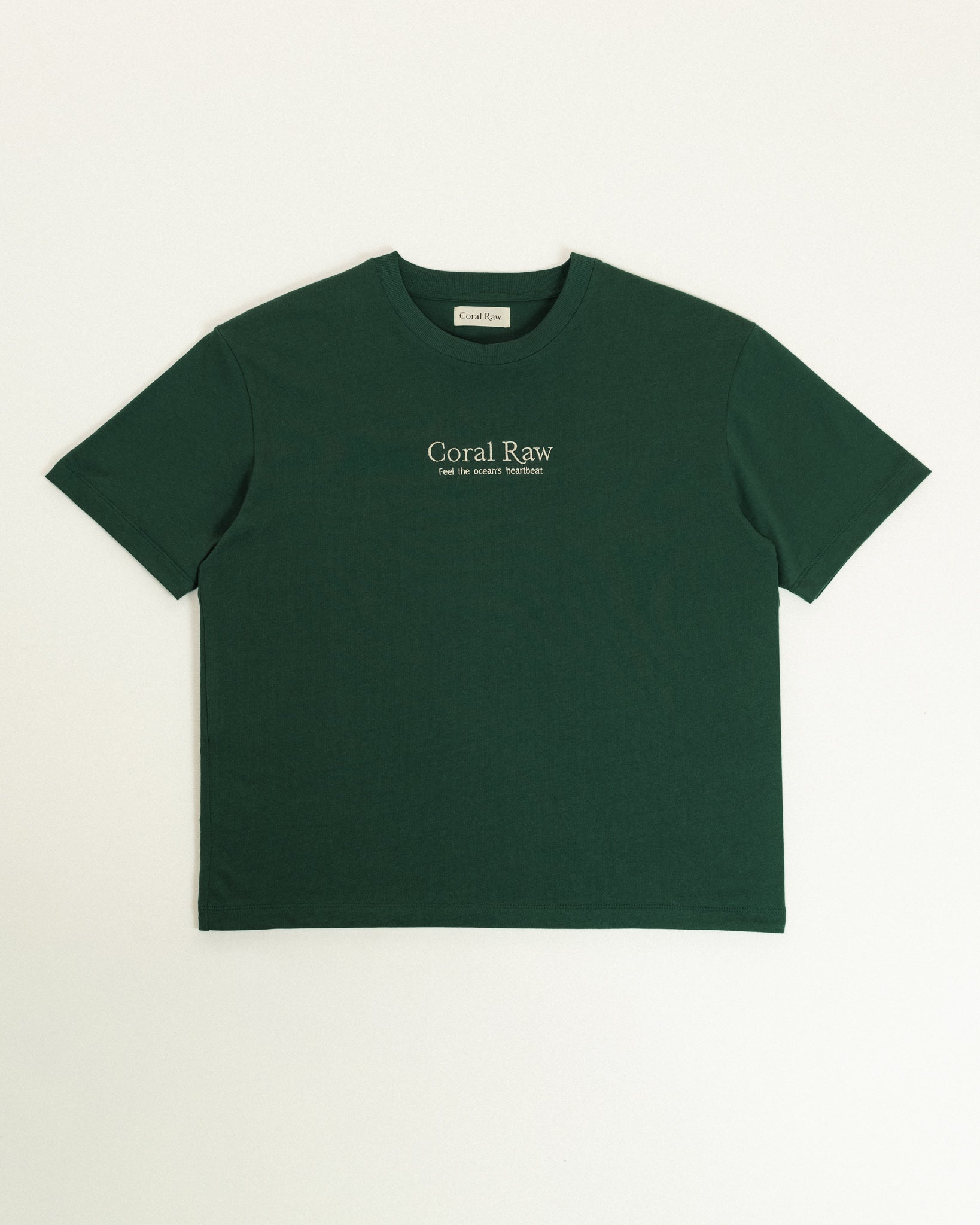 Feel the ocean's heartbeat T-shirt laid flat on a plain background.