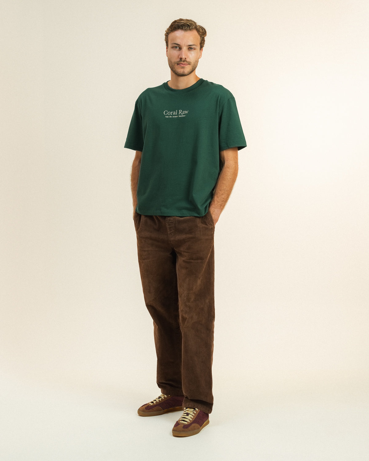Man wearing the Feel the ocean's heartbeat T-shirt by Coral Raw, full body front view.
