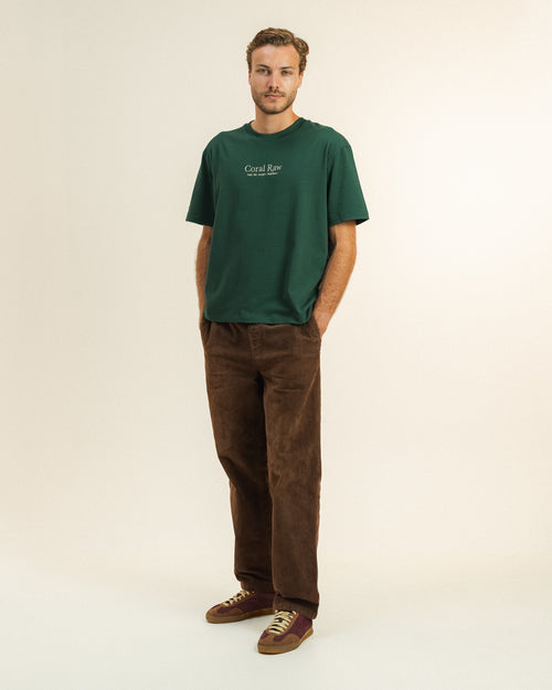 Man wearing the Feel the ocean's heartbeat T-shirt by Coral Raw, full body front view.