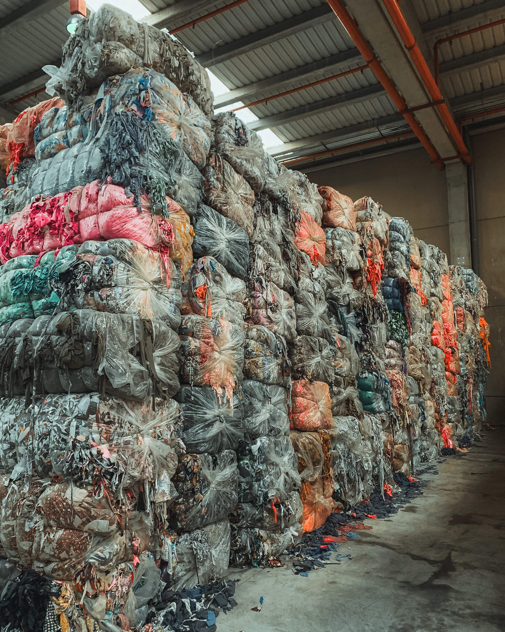Large industrial bags filled with post-consumer textile waste, ready to be transformed into CIRCULOSE® for Coral Raw garments.
