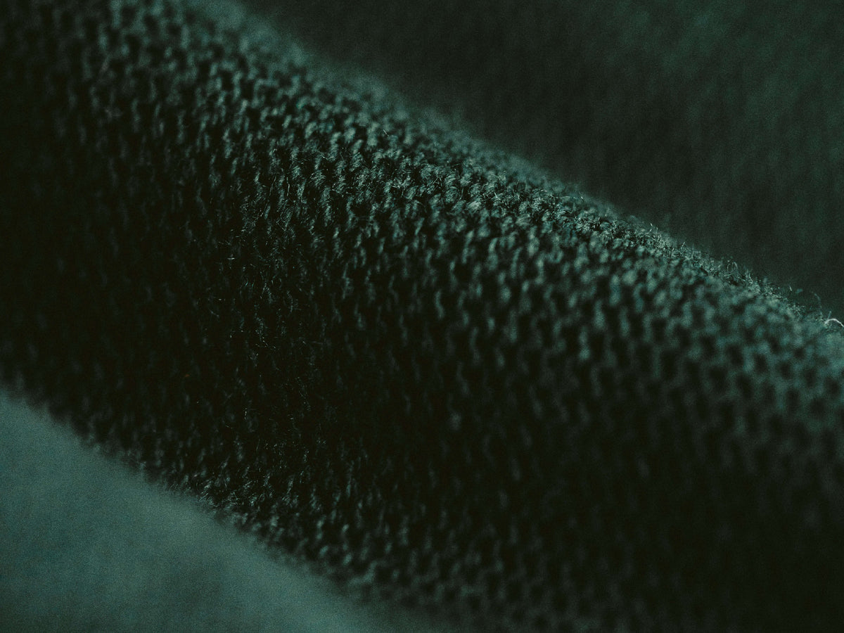 Macro close-up shot of eco-friendly recycled cotton fabric showing the sustainable textile texture.